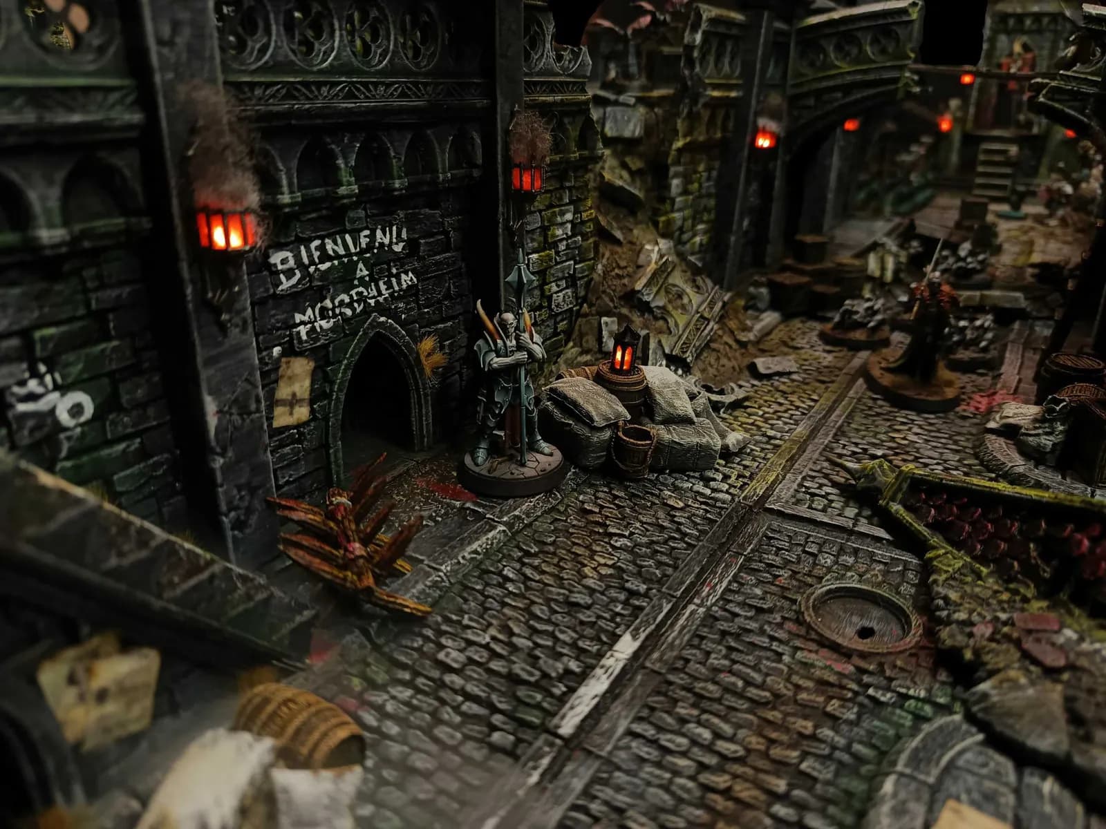 Entrée de la cité avec graffiti Bienvenue à Mordheim